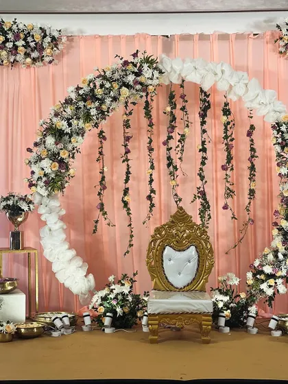 A beautiful shot of the floral ring backdrop, highlighting the soft peach and purple hues. The hanging vines and full floral arch create a romantic and enchanting setting for any special occasion.