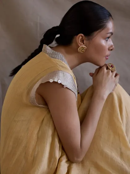 A quiet, gentle portrait for a modern ethnic wear brand. The soft yellow of the dress and the natural light create a warm and inviting feel.
