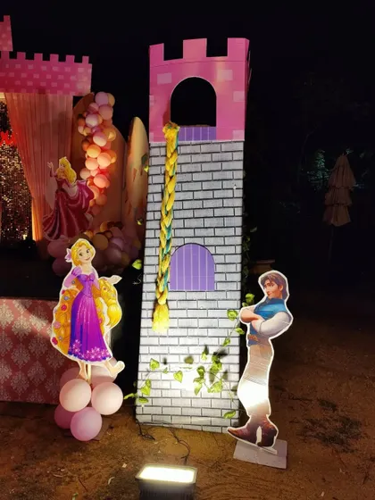 The Rapunzel tower prop with character cutouts of Rapunzel and Flynn Rider.