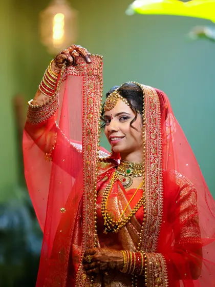 A joyful portrait of the bride lifting her veil with a smile, capturing her excitement.