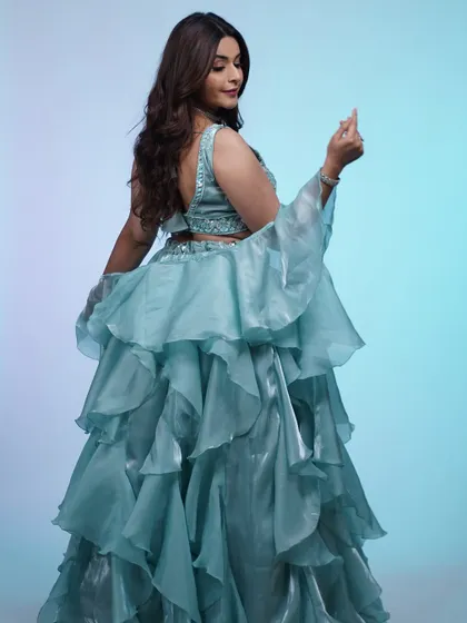 A different pose in the ruffled blue lehenga, showing off the dramatic, flowing sleeves. This outfit is all about movement and making a statement.