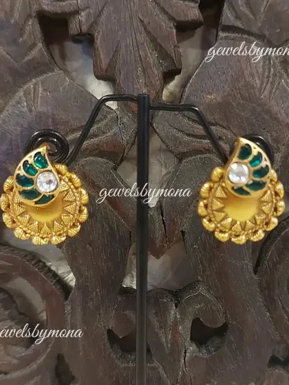 These small Dakshinaya studs are perfect for a subtle yet traditional look. The design features a classic mango motif, or 'kairi', with green enamel work, set in rich gold.