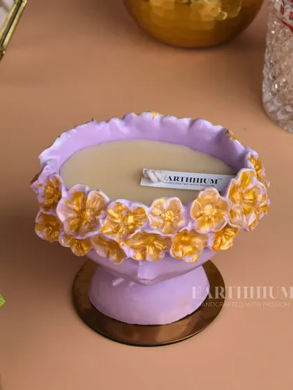 A lovely lavender Jesmonite candle holder with golden floral accents. The pedestal base gives it an elegant, elevated look.