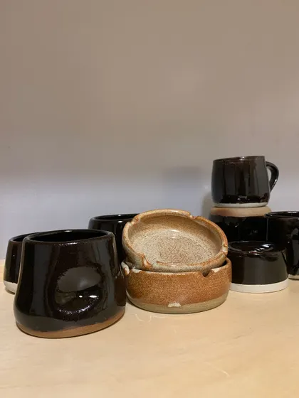 A close-up of the handmade ashtrays and mugs. The slight irregularities are a mark of their handmade journey.