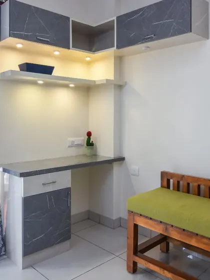 A compact and stylish study nook, perfect for a bedroom or a small apartment. The desk is complemented by overhead cabinets in a grey marble finish, providing storage without taking up floor space.