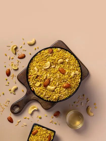 A savory Moong Dal mixture with cashews and almonds. The soft, neutral background is perfect for a clean, minimalist packaging design.
