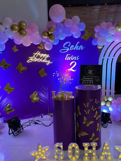 We love executing fun themes like this butterfly party for 'SOHA'. The purple backdrop is adorned with golden butterflies, which are also found on the plinths, tying the whole theme together with the balloon decor and personalized name.