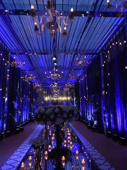 A study in blue. This royal blue-themed entrance featured dramatic draping, elegant chandeliers, and a mirrored walkway, reflecting the light to create an endless, enchanting path for guests.