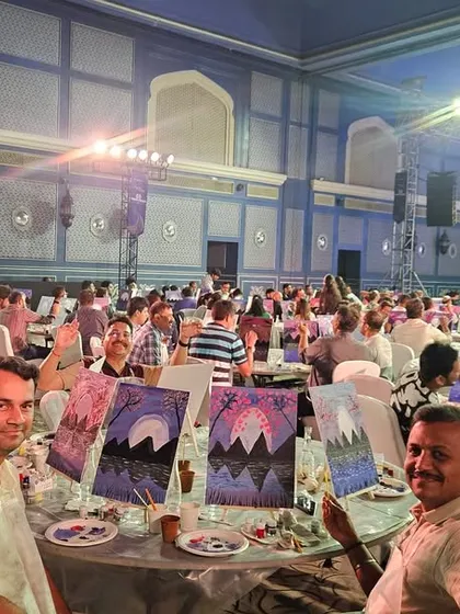 A table of participants proudly showing their work at a corporate event. Creating a fun, team-building atmosphere is crucial for corporate clients, and it's a skill that leads to repeat business and referrals.