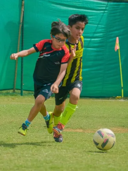 Shoulder to shoulder, two players fight for the ball, showcasing the physical but fair nature of the game.