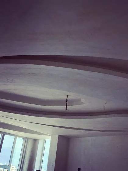 Another example of intricate ceiling work under construction. This image shows the creation of a curved, multi-layered false ceiling, highlighting our team's skill in executing complex and custom designs.