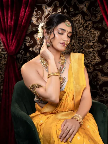 A relaxed, seated pose that still showcases the elegance of the full jewellery set.