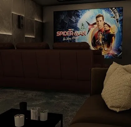 Even with the lights on, the screen is ready for action. This view shows a more casual seating area in the foreground, with the main recliners in the back.