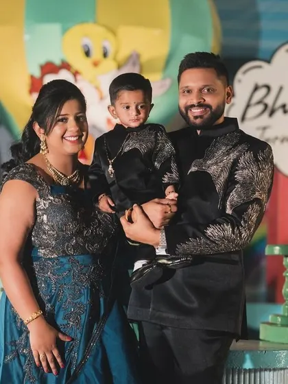 A happy family portrait of Bhuvik and his parents at his Looney Tunes first birthday party.
