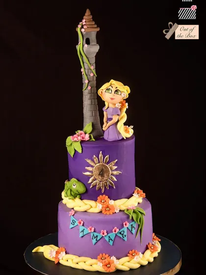 A beautiful two-tier Rapunzel cake in purple, featuring her tower, braided hair, and the magical sun crest.