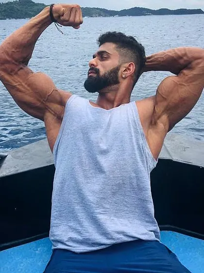 Enjoying the outdoors while still keeping an eye on the physique. This pose on a boat shows the results of hard work in a different, more relaxed setting.