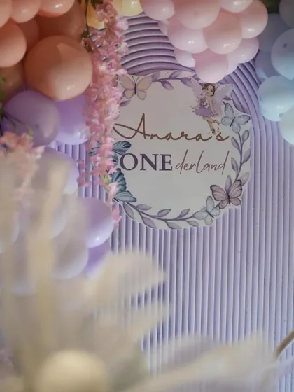 A detail shot of the 'Anara's ONEDerland' sign. The custom calligraphy and whimsical design elements tie the whole theme together.