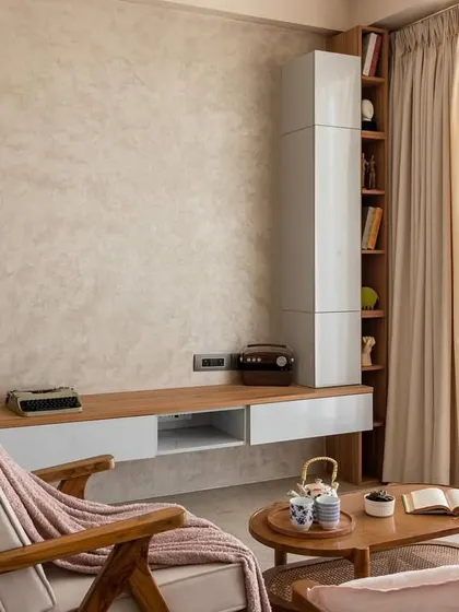 We love the understated beauty of a nude color palette. This view shows the TV unit with its textured wall and vertical wooden slats, adding depth and interest without overwhelming the space.