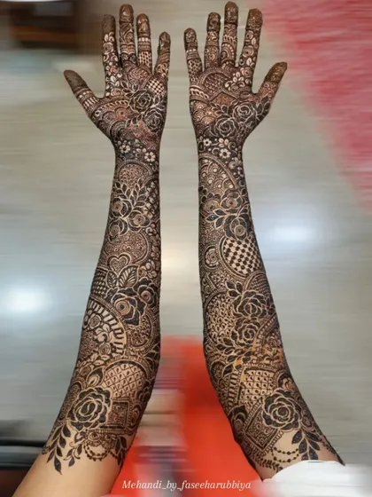 A full view of Neha's bridal hands, featuring a mix of bold roses and delicate, intricate filler work.