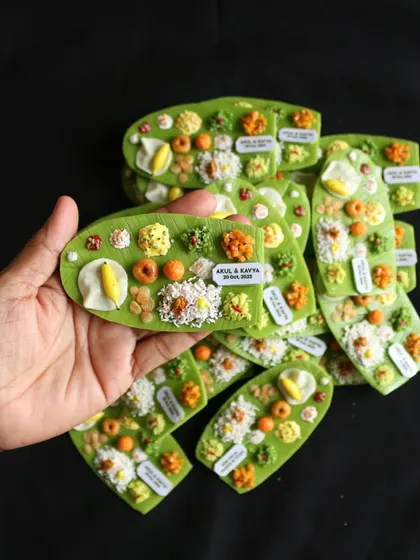 Holding a handful of custom-made South Indian meal magnets, showcasing the detail and care that goes into each piece.