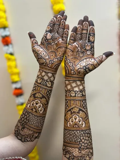 A beautiful bridal design with a mix of paisleys, florals, and geometric patterns. The symmetry in the design creates a harmonious and balanced look, perfect for a wedding.