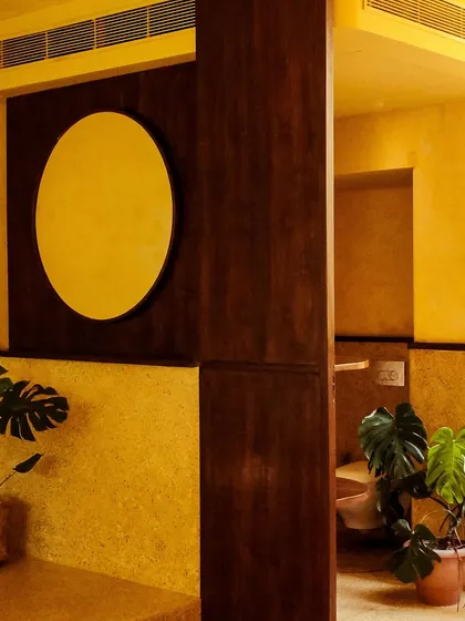 The clean, minimalist design extends to every corner, with potted monstera plants adding a touch of vibrant green.