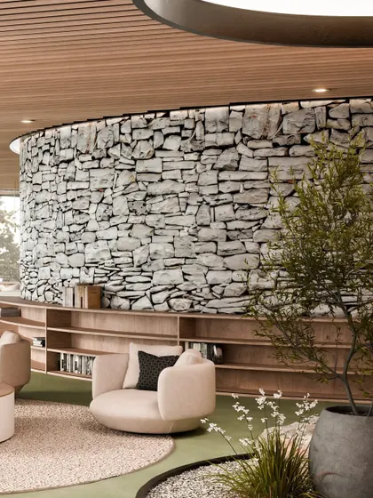 A cozy reading nook in the lounge, with a curved stone wall and built-in wooden bookshelves.