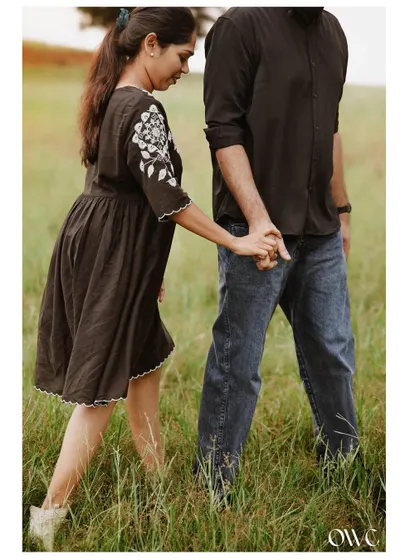 A close-up on the couple's hands as they walk through a field, a simple yet powerful symbol of their connection.