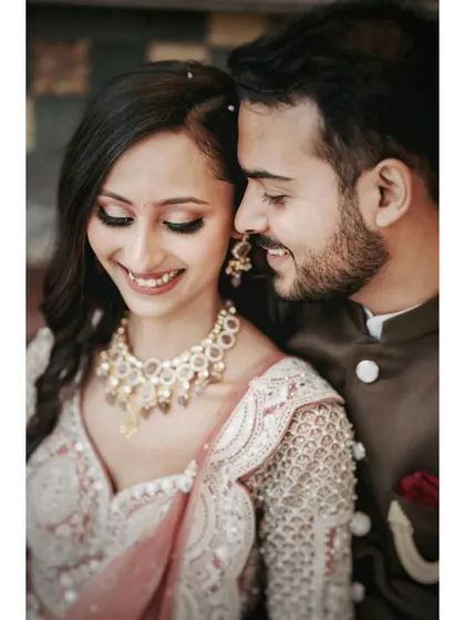 A close-up portrait that highlights the couple's happy smiles and the bride's intricate jewelry and makeup. These detail shots are perfect for remembering your engagement look.