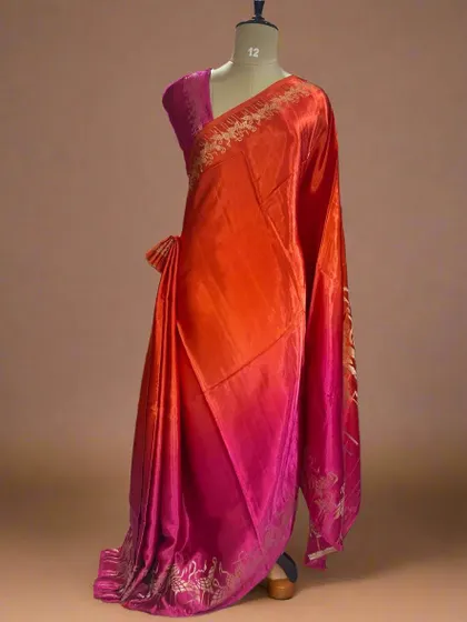 A vibrant shaded satin crepe saree with a flamingo border, blending from orange to pink.