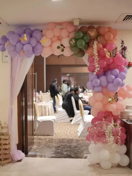 The entrance to Anara's 'Onderland' party, featuring a beautiful balloon arch in soft pastel colors with butterfly accents.