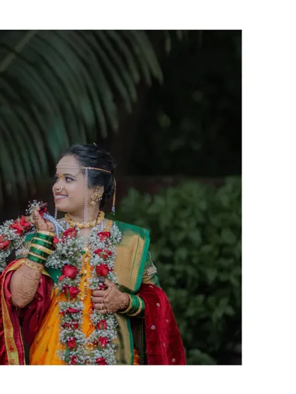 The bride, adorned in her traditional saree and holding the flower garland, captured in a moment of quiet anticipation.