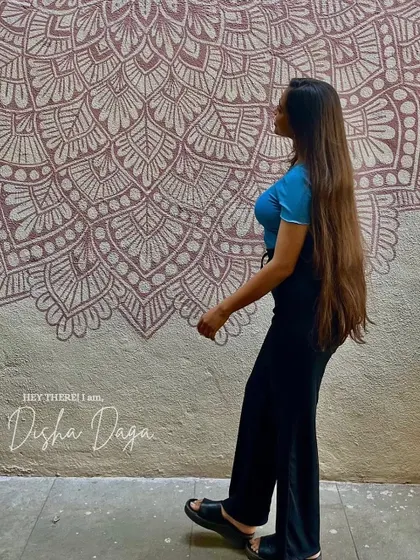 Hey there, I am Disha Daga. A photo of me with one of my murals, a reminder of how far I've come on this incredible journey.