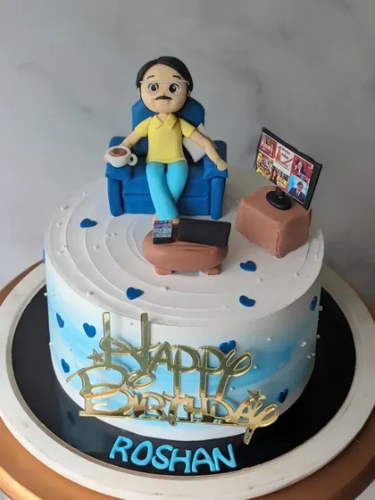 A theme cake ordered by a wife for her husband's birthday. It shows him relaxing with a cup of tea and watching TV, capturing a perfect moment of downtime.