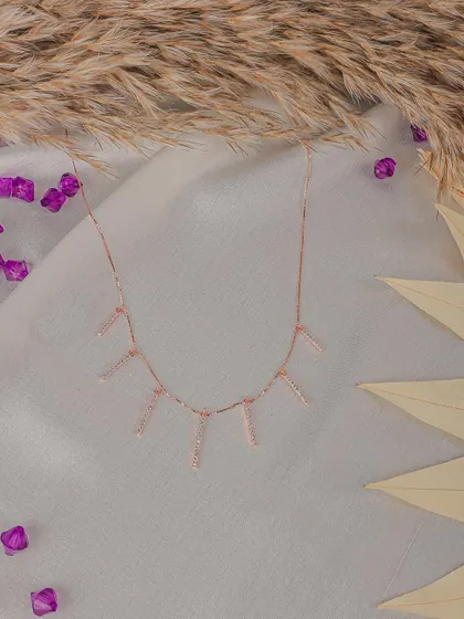 This minimalist necklace is styled against a neutral, textured background with dried wheat stalks. The composition is designed to be clean and aesthetically pleasing for product listings.