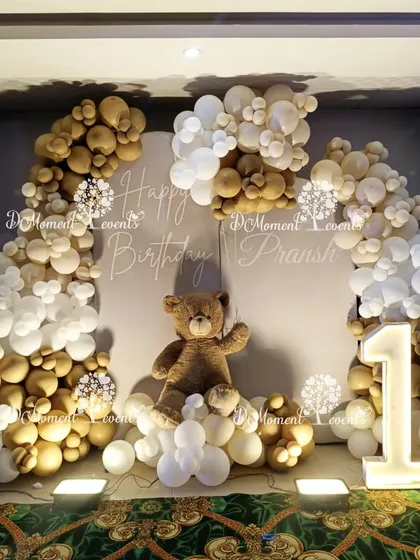 A classic and cozy teddy bear themed backdrop, using a neutral color palette of brown, beige, and white balloons with a large, cuddly teddy bear as the centerpiece.
