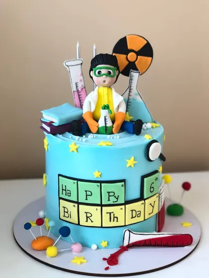 A fun science-themed cake for a young chemist, featuring periodic table elements, beakers, and a scientist topper.