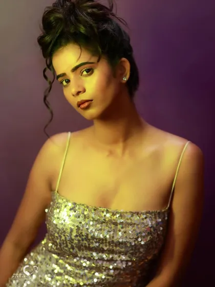 A beautiful portrait with dramatic lighting. The yellow light on her skin creates a warm glow against the cool purple background.