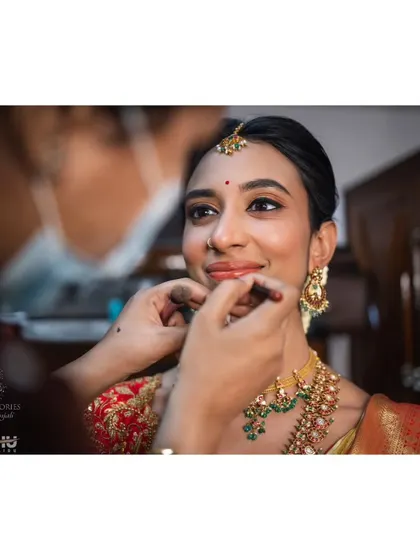 Another shot from Ritika's getting ready session. This shows the final touches to her jewelry, with her makeup looking soft, radiant, and perfectly suited to her preferences.