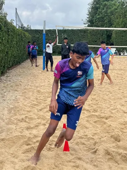 A player navigates an agility course on the sand, showing focus and determination.