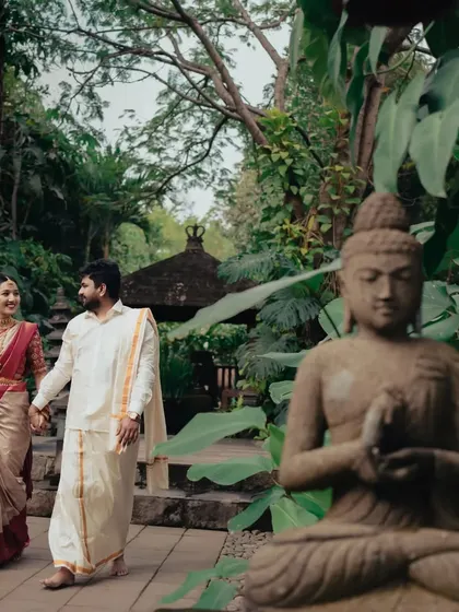 A post-wedding stroll through a serene, temple-like garden. This shot captures the couple hand-in-hand, embarking on their new journey together.