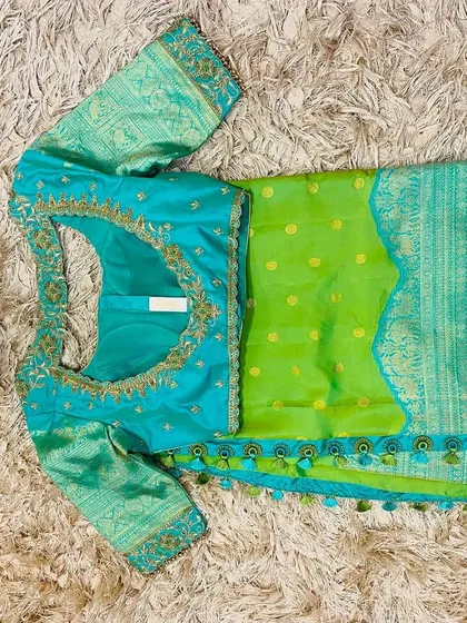 A seafoam blue embroidered blouse paired with a parrot green silk saree, a fresh and modern color pairing.