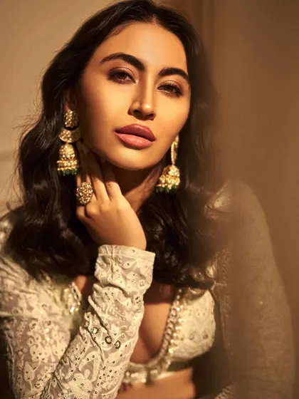 A close-up on the soft glam makeup and beautiful traditional jhumkas. The golden hour lighting really makes the skin glow.