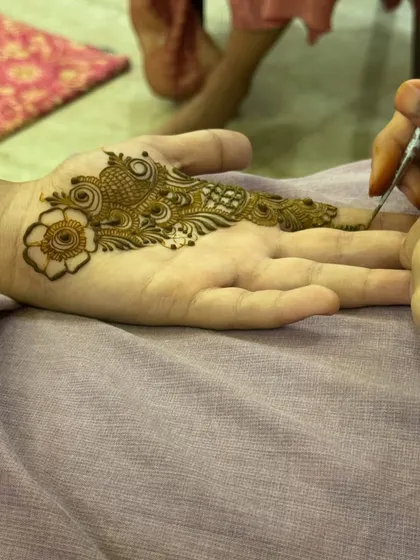 A work-in-progress shot of a modern design, showing the application of a bird motif on the palm.