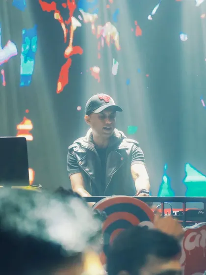 A shot of me at the console, surrounded by light and smoke. The abstract visuals on the screen behind me are part of the curated visual journey I take the audience on during my sets.