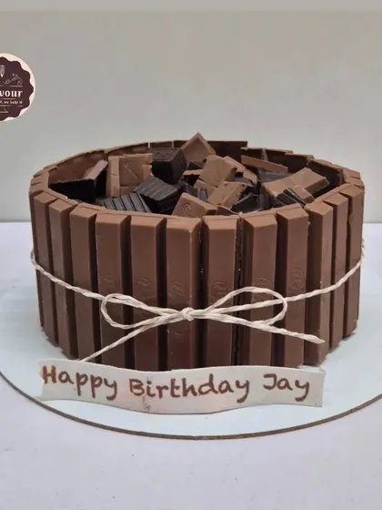 A classic Kit Kat cake. The sides are lined with Kit Kat bars, and the top is filled with chopped chocolate, making it a crunchy, chocolatey dream.