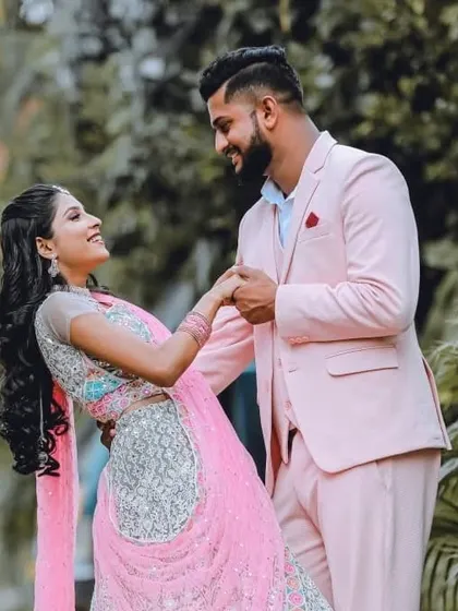 I love creating perfectly coordinated looks. Here, my client looks dapper in a custom pastel pink suit, perfectly complementing his partner's beautiful pink and silver lehenga. It's all about capturing your connection in style.