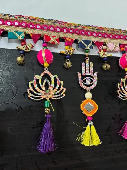 The full view of the 'Shubh Toran' hanging. The combination of tassels, beads, bells, and symbolic shapes creates a rich, layered look that is both traditional and modern.