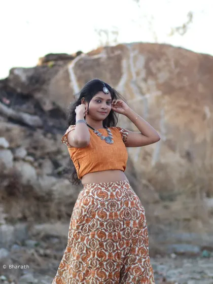 A dynamic outdoor portrait, capturing movement and style in a beautiful, traditionally inspired outfit.