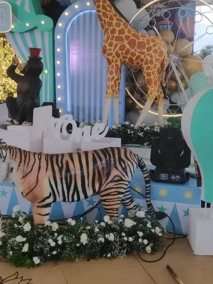 A close-up of the life-size tiger prop and hot air balloon decoration on the pastel circus stage.